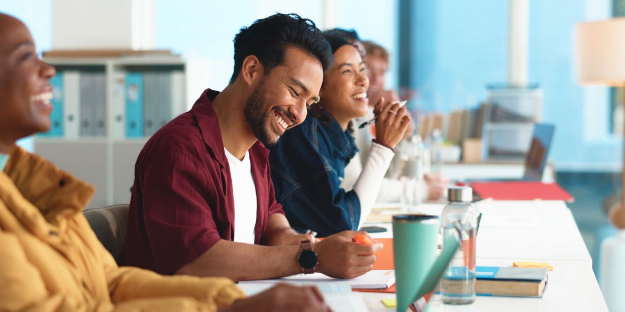 Group of diverse people laughing and studying together.