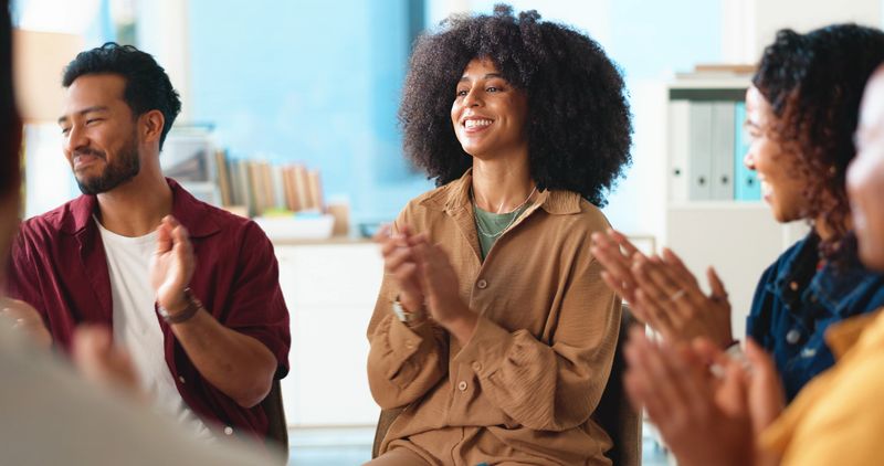 Excited people, support group and meeting with applause for congratulations, thank you or well done. Happy, team or employees clapping with smile for promotion, bonus or winning together in workplace