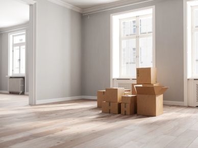 Empty room with cardboard boxes stacked near window for move-in and move-out cleaning