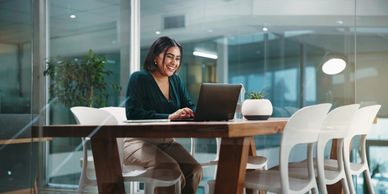 A woman working on a laptop in a modern office space.