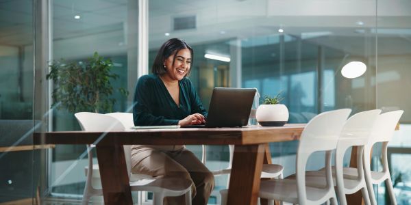 Woman working on laptop in modern office.