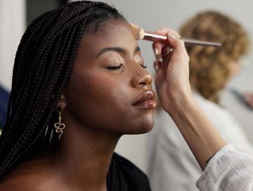 Woman having makeup applied on her forehead.