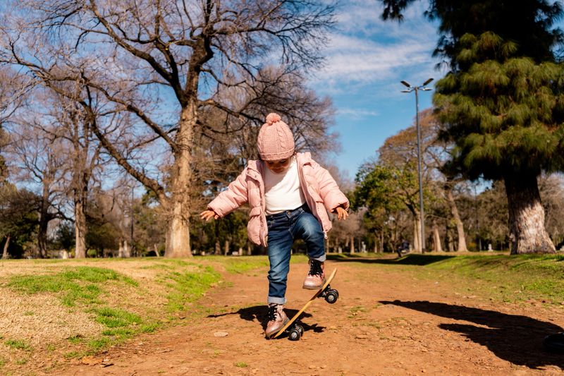 A giggling toddler playing in a sunny park, captured in a candid moment.