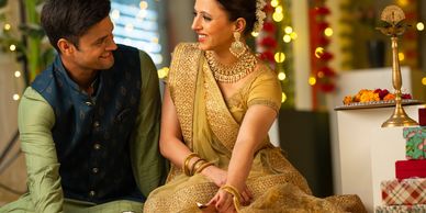 Couple dressed in traditional Indian attire sharing a joyful moment.