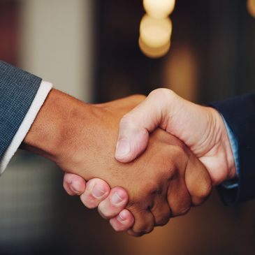 Two people shaking hands in a professional setting.