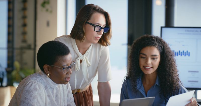 Business, people and reading document in office for accounting, finance report and planning. Women, meeting and check paperwork for financial results, information and teamwork for investment proposal