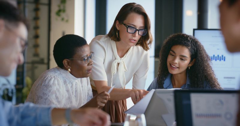 Business, people and explain with document in office for accounting, finance report and planning. Women, reading and paperwork with financial results, information and teamwork for investment proposal