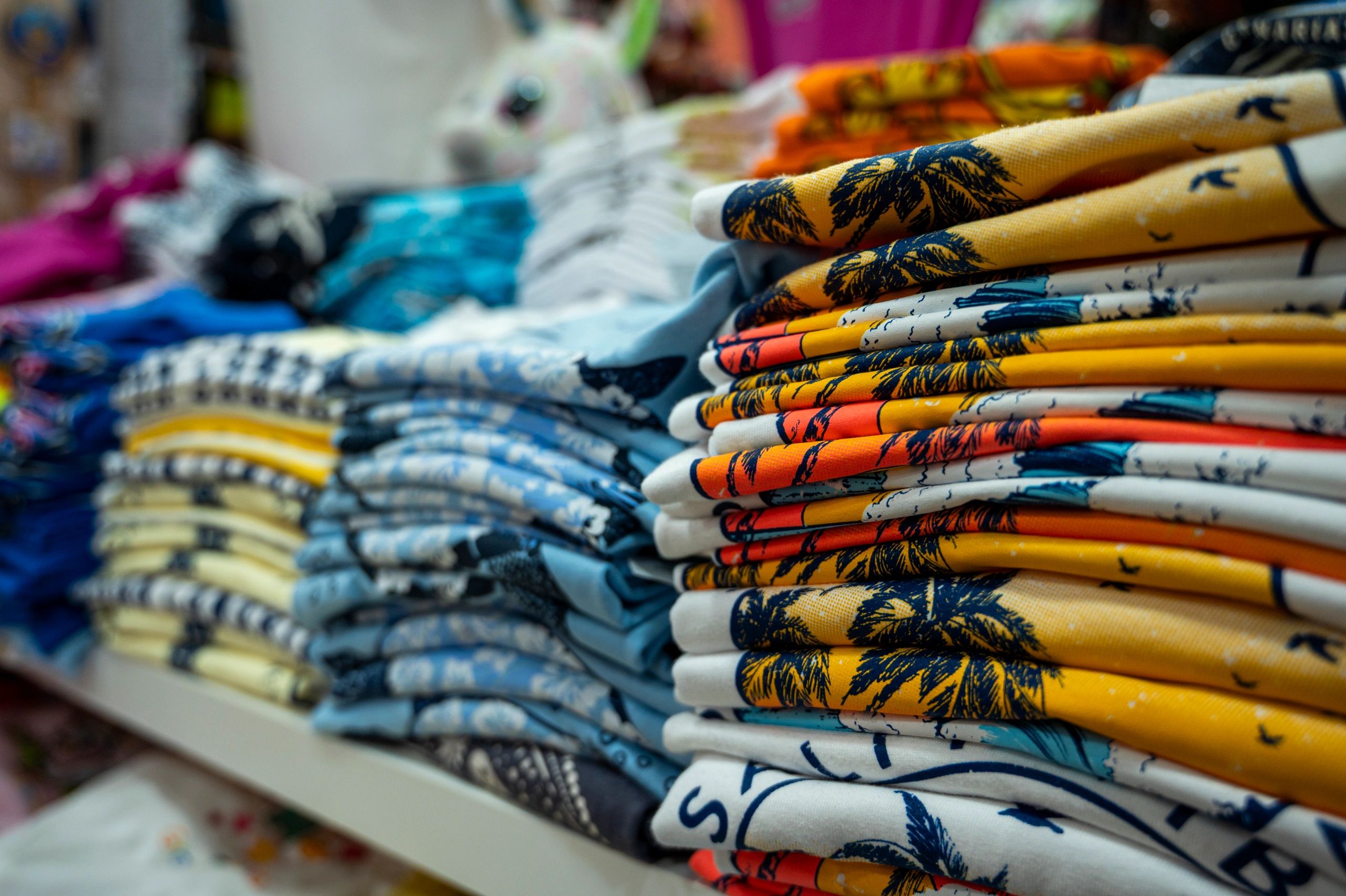 Stacks of folded colorful printed shirts.