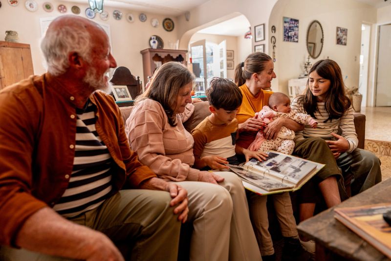 Family looking a photo album together at home