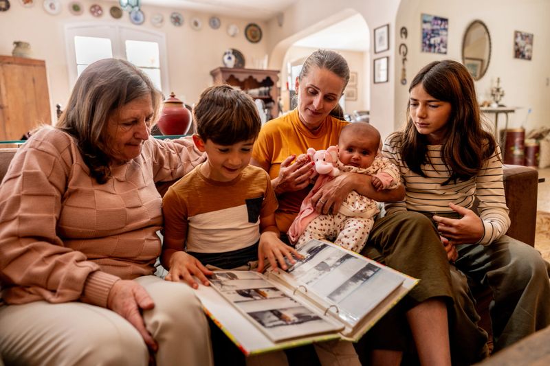 Family looking a photo album together at home