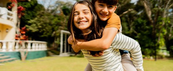 Diverse children smiling outdoors.