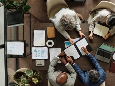 Three business people collaborating over documents in an office.