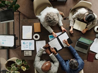 Top view of four professionals reviewing documents together.
