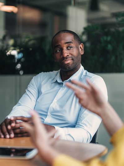 Man attentively listening in a conversation at a table.