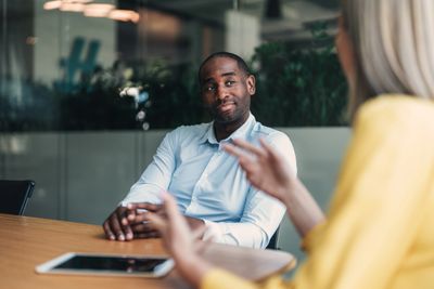 Man listening attentively during a conversation in an office setting.