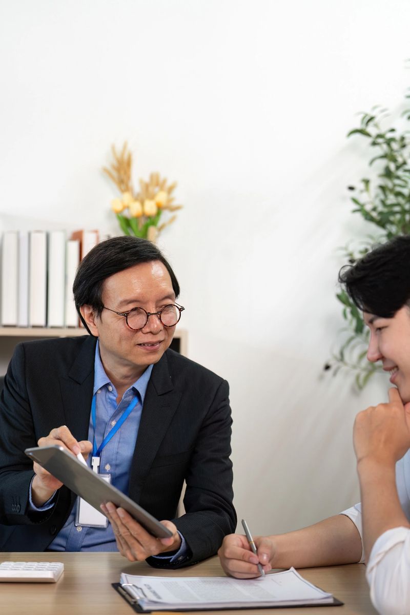 A businessman discusses insurance policy details with a client, showcasing a collaborative atmosphere in a modern office.