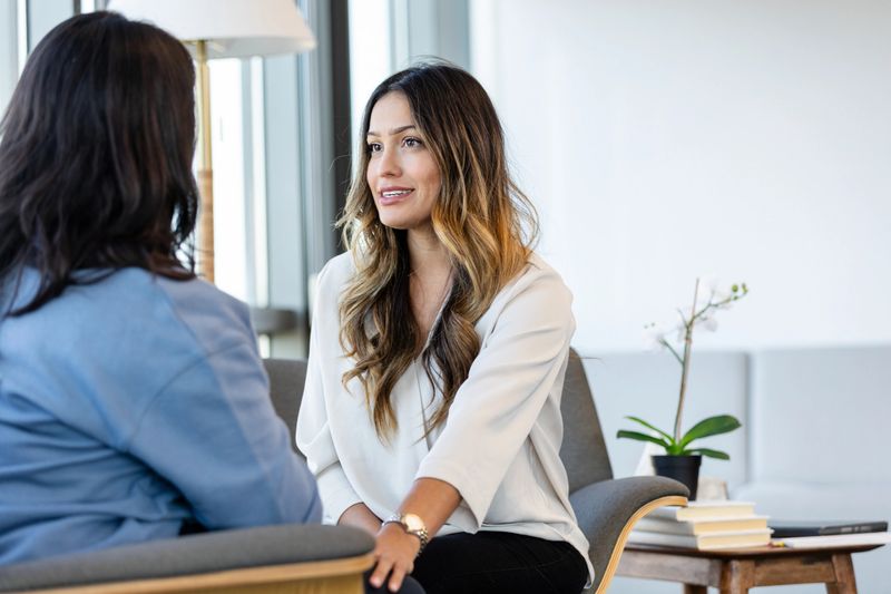 Mental health professional and patient discussing emotional wellbeing in an office.
