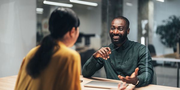 Two colleagues having a friendly discussion in an office.