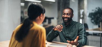 Two colleagues having a friendly conversation in an office.