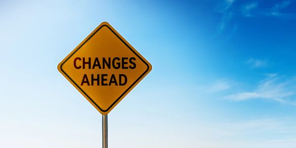 Yellow road sign saying 'Changes Ahead' against a blue sky.