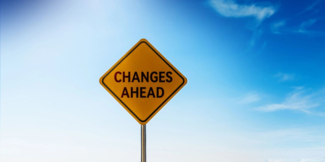 Yellow road sign saying 'CHANGES AHEAD' against blue sky.