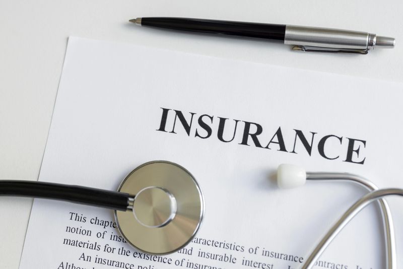 Health insurance form with pen and stethoscope on table