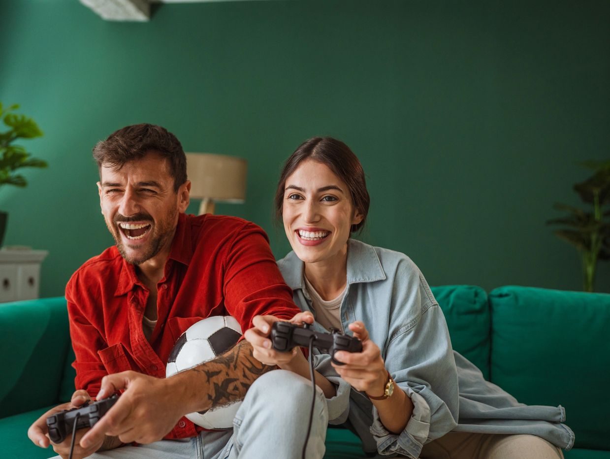 Couple playing video games and having fun on the couch.