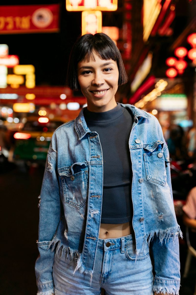 Portrait of a cheerful young woman standing in a vibrant chinatown street at night