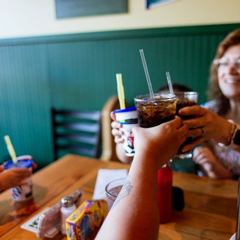 Family fun day: a multigenerational Latine family go out for pizza at a local restaurant. There is a grandmother, mom and two daughters in this family as they enjoy quality time together.