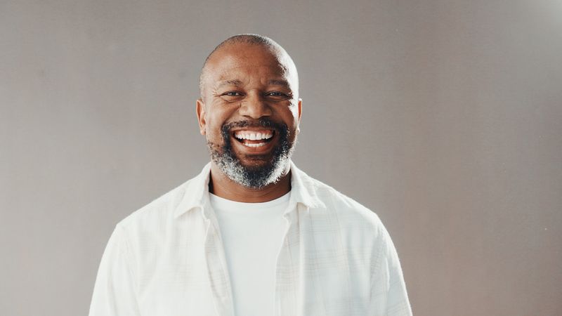 Happy, professional and portrait of black man in studio with confidence for career development. Smile, male person and mature African financial advisor with pride for job by gray background.