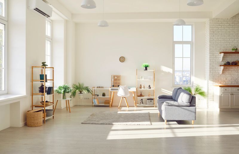 Modern interior of spacious contemporary living room in Scandinavian style with open concept with trendy furniture, plants, carpet, desk, sofa and stylish home decor. Interior design concept.