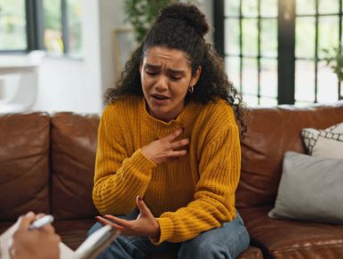 Woman expressing distress during a therapy session.