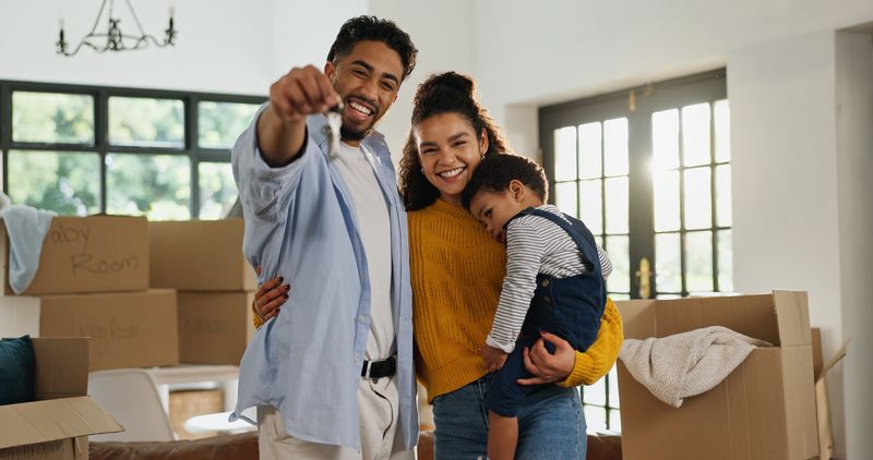 Keys, smile and portrait of family in new home for moving, property investment and security. Happiness, mortgage approval and real estate with parents and child in living room of house for rent