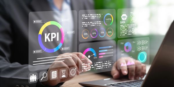 Person interacts with digital KPI data on a laptop.