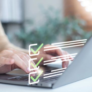 Person typing on laptop with digital checkmarks floating above keyboard.