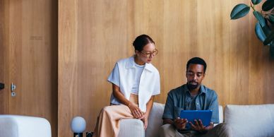 Two people reviewing content on a tablet together.