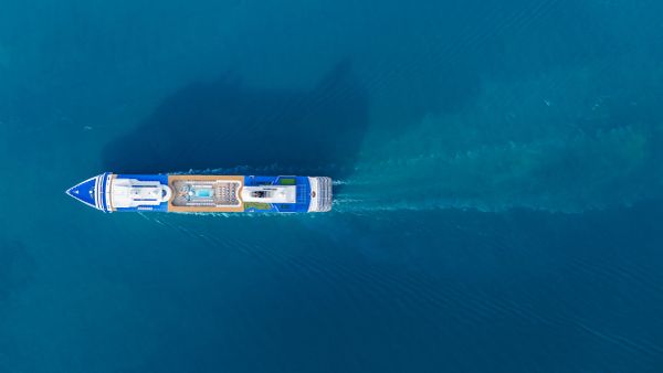 Aerial view of a cruise ship on clear blue water.