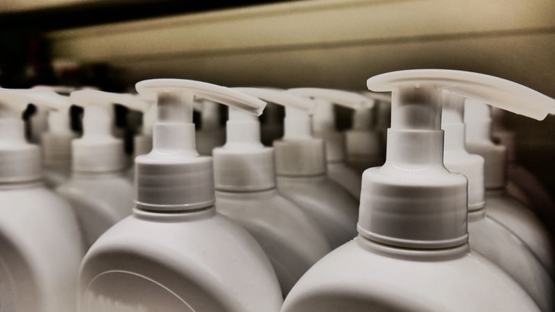 Many white dispenser bottles of liquid soap