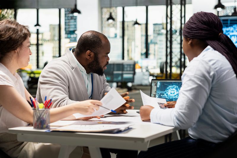 Recruiters reviewing feedback from artificial intelligence platform, using automation and deep learning to make informed hiring decisions and select suitable applicants for employment.