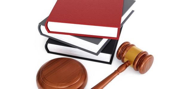 Stack of law books with a judge's gavel and sound block.