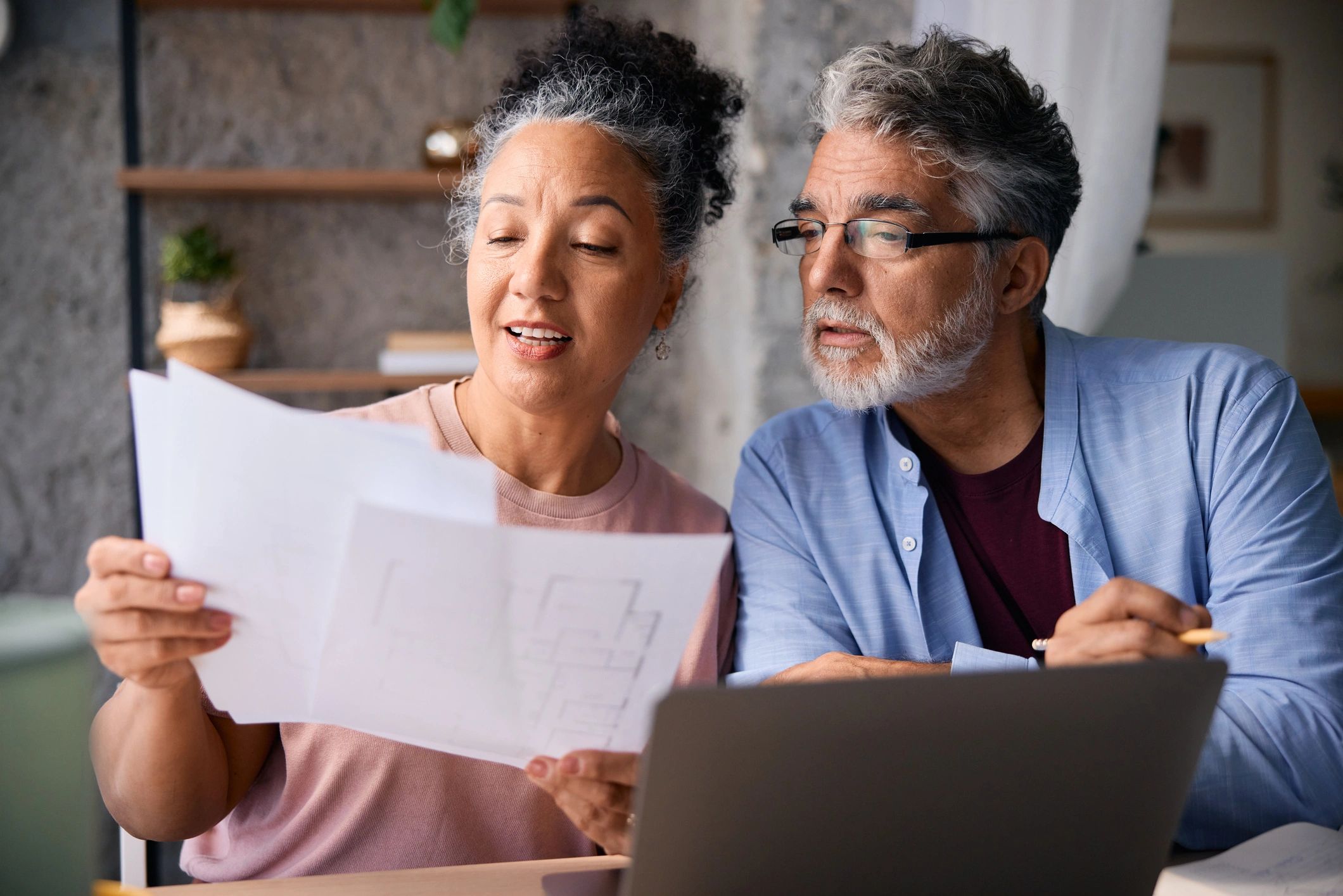 Mature couple reviewing documents together at home.
