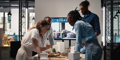 Four colleagues brainstorm intensely around a table in a modern office.