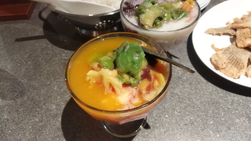 A vibrant Indonesian Es Campur dessert featuring ripe mango and avocado. A delightful treat