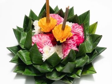 Traditional Thai krathong made of banana leaves, flowers, and incense sticks.