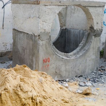 Concrete structure with circular opening at a construction site.