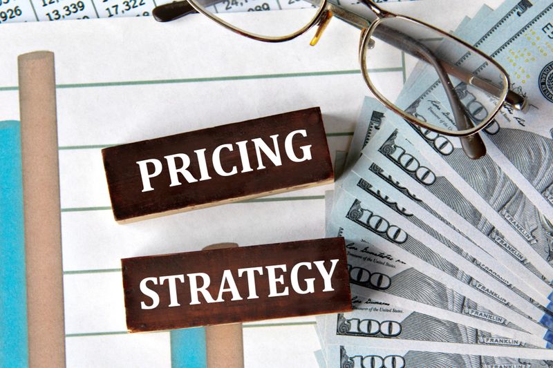 PRICING STRATEGY - words on brown wooden blocks on the background of a graph and banknotes