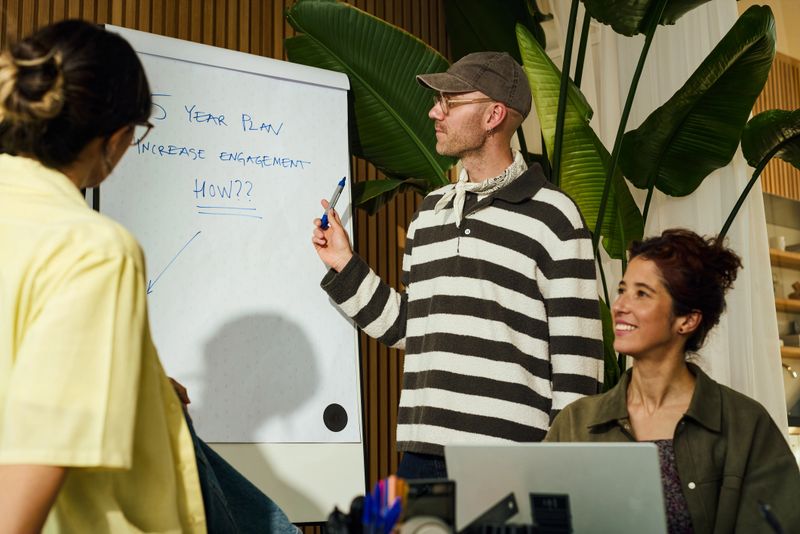 Diverse team brainstorming new business ideas during a meeting, focusing on a five-year plan for increased engagement