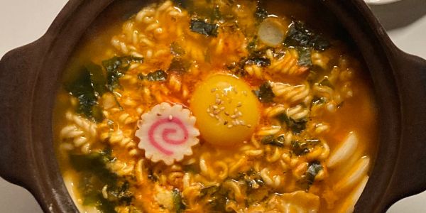 A bowl of spicy ramen with egg and seaweed.
