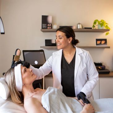 A skincare professional attending to a client in a cozy setting.