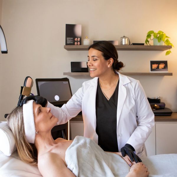 A woman receiving skincare treatment from a professional.
